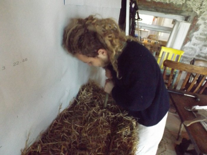 William driving a willow stake through the first two layers of bales