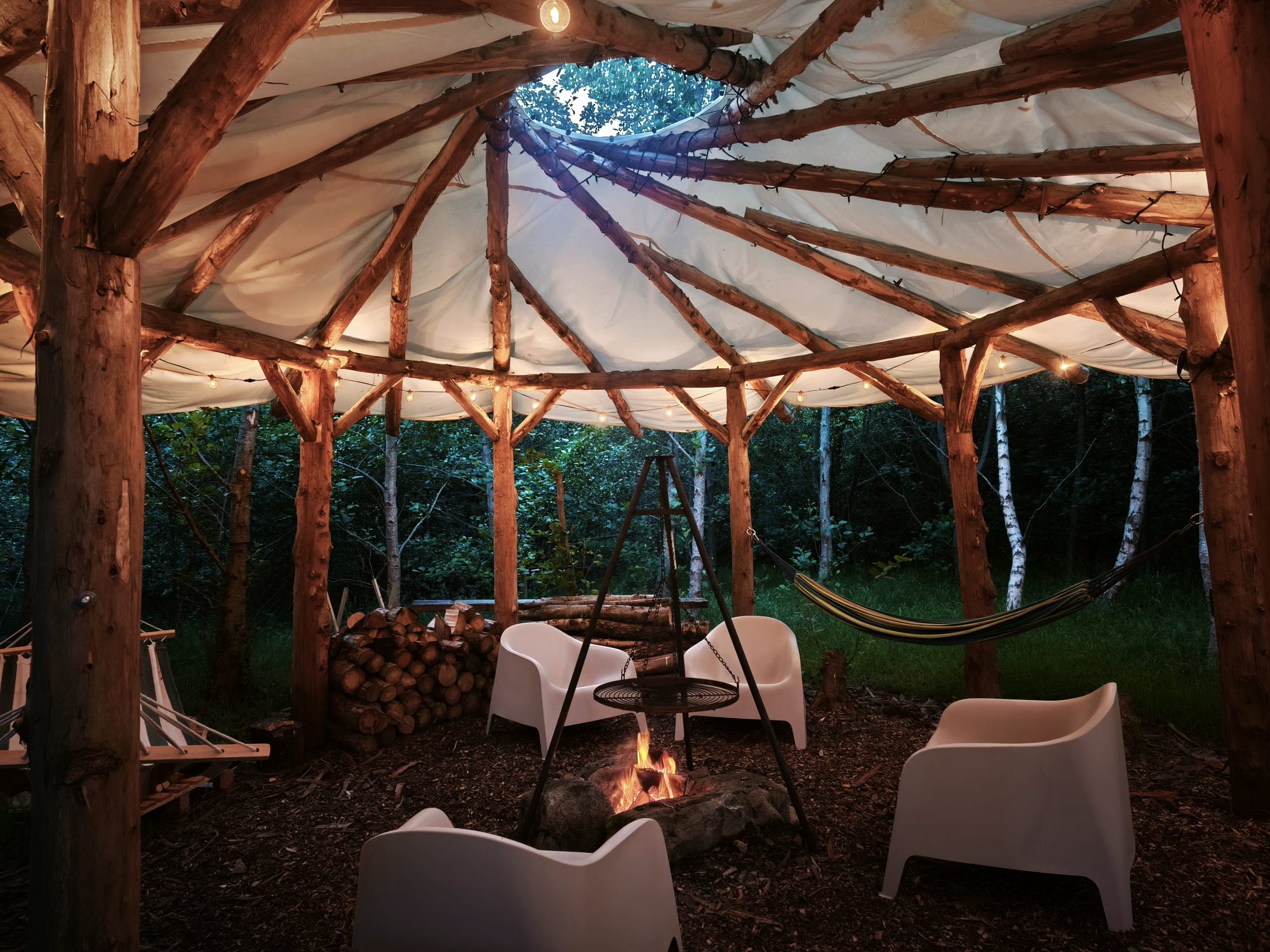 A covered fire pit area with decorative lighting